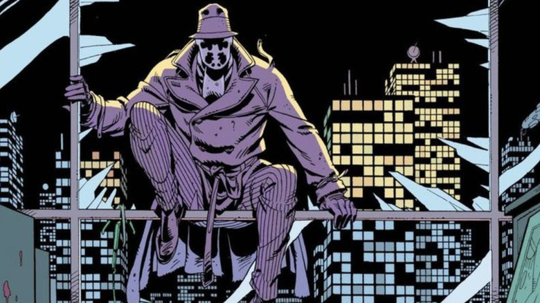 Rorschach sentado en el marco de una ventana rota en Watchmen