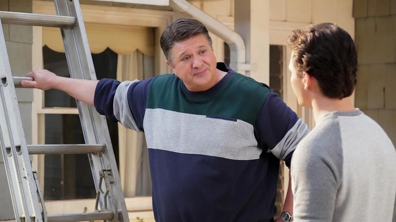 Lance Barber as George Sr. leaning against a ladder in Young Sheldon