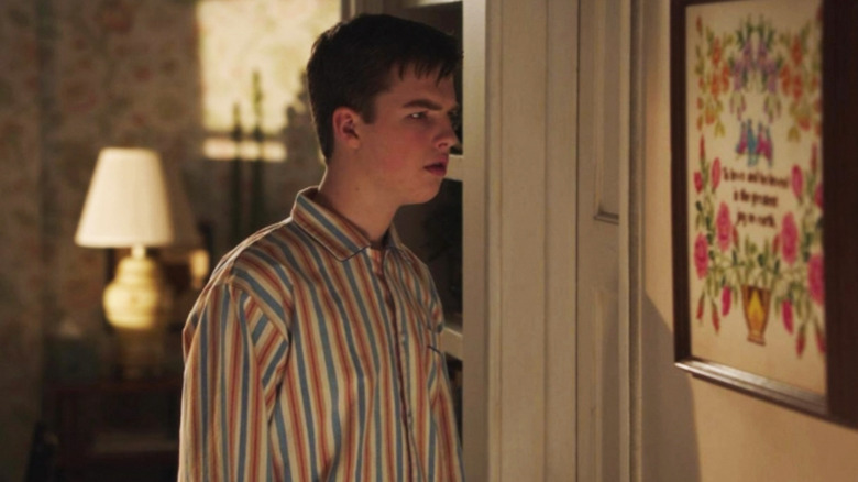 Sheldon of Iain Armitage looks disturbed by standing near a door of the room in Young Sheldon