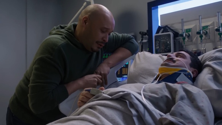 Joe Minoso's Cruz cries by the hospital bed of Yuri Sardarov's Otis in Chicago Fire