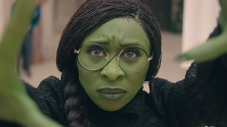 Cynthia Erivo as Elphaba reaching forward with a furrowed brow in Wicked