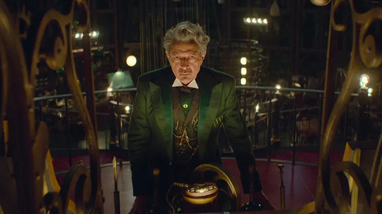 Jeff Goldblum as The Wizard expressionless in his lair in Wicked