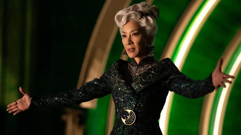 Michelle Yeoh as Madame Morrible spreading her hands in Wicked