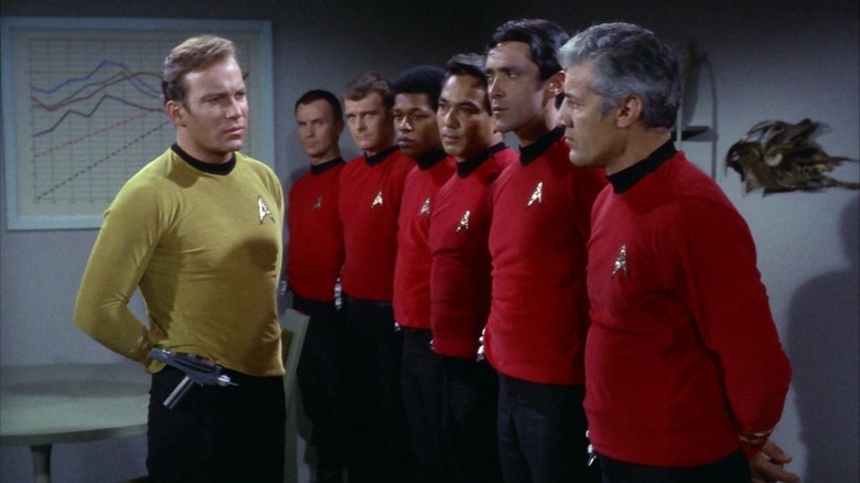 Captain Kirk standing in front of a line of redshirts