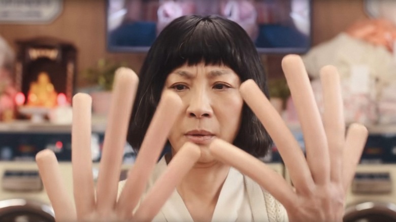 Michelle Yeoh with hotdog hands in Everything Everywhere All At Once