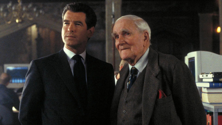 Pierce Brosnan as Jamed Bond standing with Desmond Llewelyn's Q in The World is Not Enough