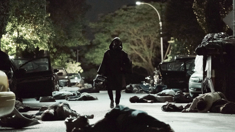 hooded figure in shadow walking down a street at night amid dead bodies and abandoned cars