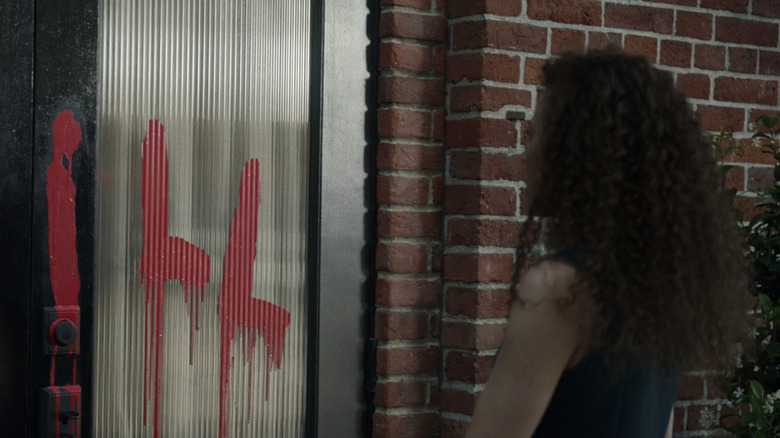 Taissa finding "Spill" vandalized on her building