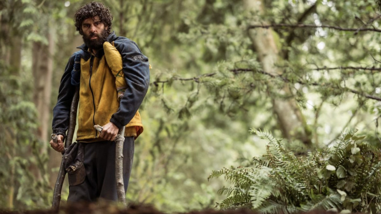 Coach Ben standing on crutches in the wilderness on Yellowjackets