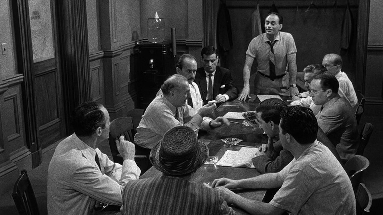 The jurors converse while seated around a table in 12 Angry Men